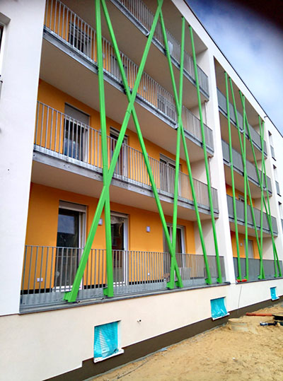 Geländeranlage Mehrfamilienhäuser mit grünen Fassadenstäben